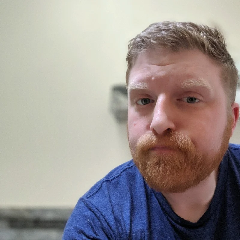 Josh Burgess, sitting on the toilet, but you wouldn't know that because it's just his head (unless you read alt texts).